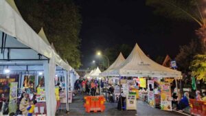 Deretan tenda putih jajanan dan kuliner UMKM di Night Market Ngarsopuro Solo pada malam hari.