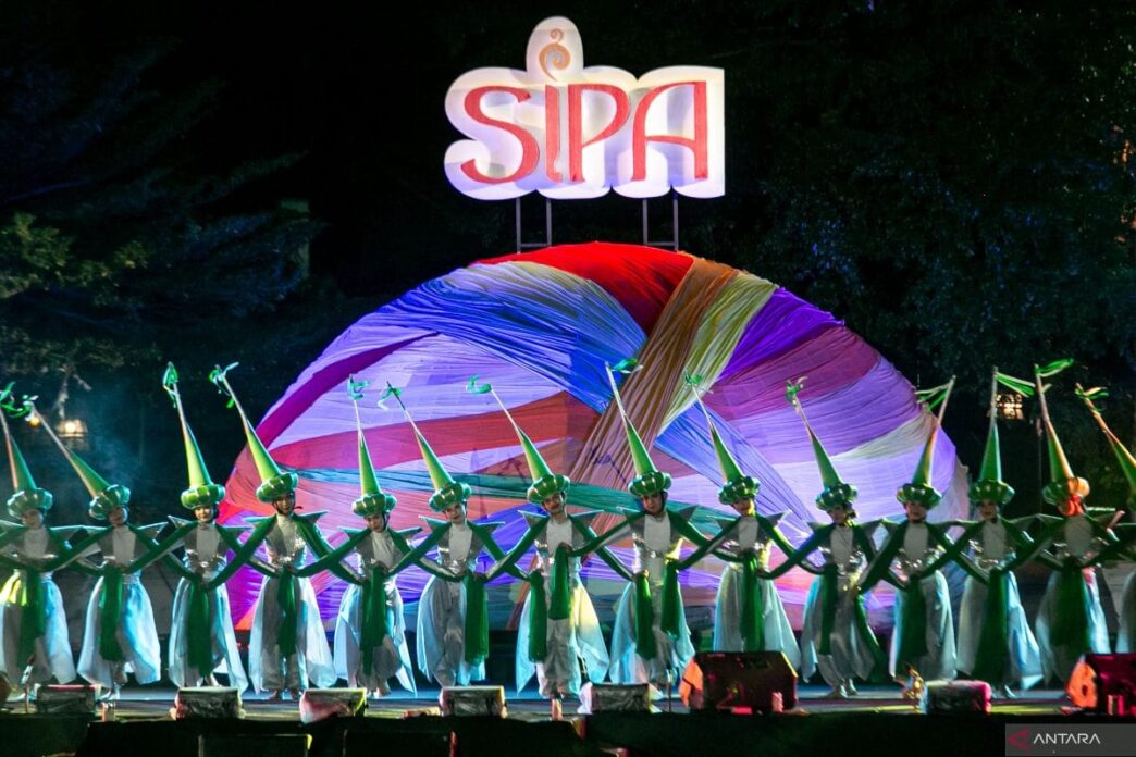 Penari berbusana hijau dan putih tampil di panggung festival Solo International Performing Arts (SIPA) dengan latar belakang dekorasi bundar dan logo SIPA yang menyala.