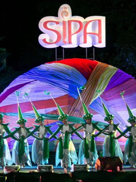 Penari berbusana hijau dan putih tampil di panggung festival Solo International Performing Arts (SIPA) dengan latar belakang dekorasi bundar dan logo SIPA yang menyala.