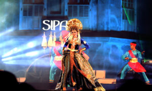 Penari wanita berbusana adat dan mahkota emas tampil di panggung Solo International Performing Arts (SIPA).