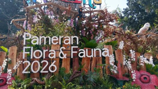 Instalasi pameran berstruktur kayu dihiasi tanaman hias, bunga anggrek, replika bunga Rafflesia, serta ornamen satwa dengan tulisan Pameran Flora & Fauna 2026.