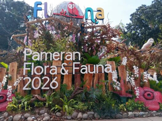 Instalasi pameran berstruktur kayu dihiasi tanaman hias, bunga anggrek, replika bunga Rafflesia, serta ornamen satwa dengan tulisan Pameran Flora & Fauna 2026.