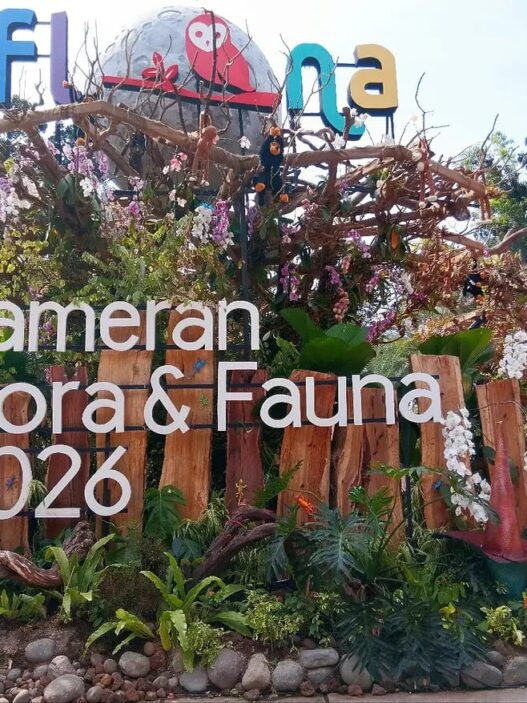 Instalasi pameran berstruktur kayu dihiasi tanaman hias, bunga anggrek, replika bunga Rafflesia, serta ornamen satwa dengan tulisan Pameran Flora & Fauna 2026.