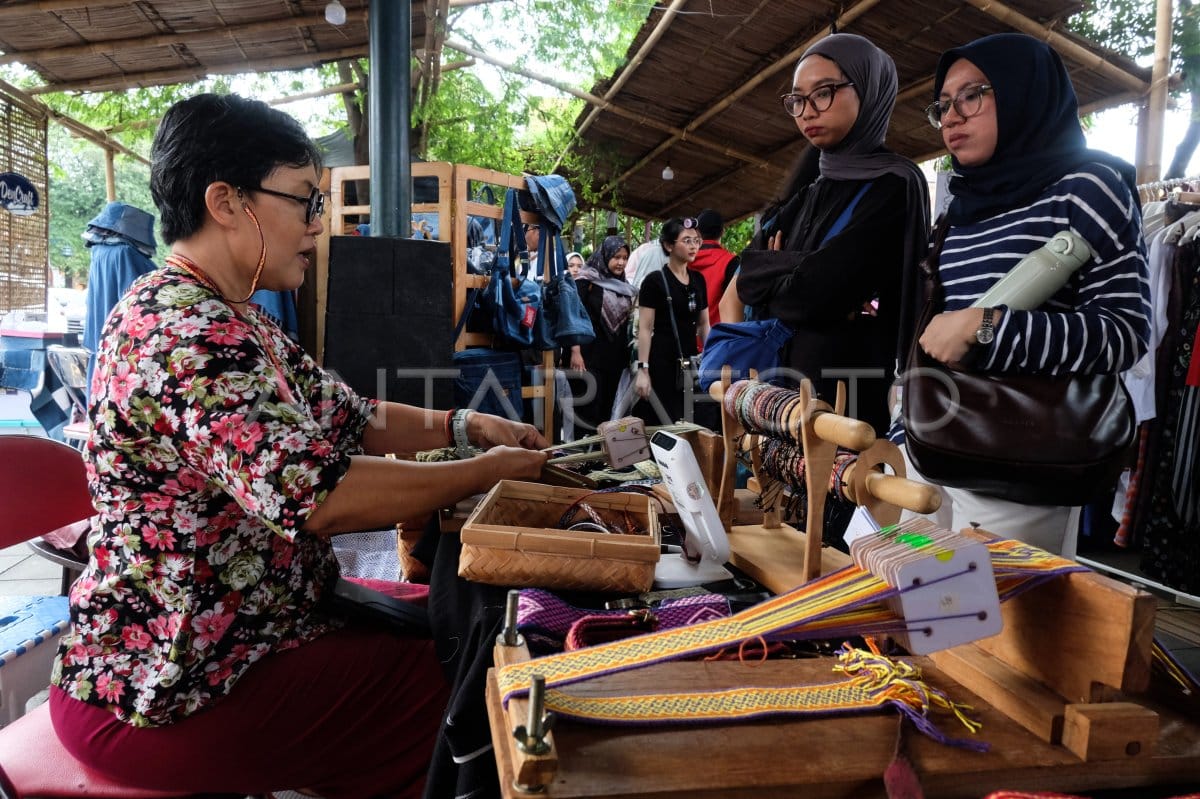 Demonstrasi penenunan kerajinan tangan oleh penenun lokal kepada pengunjung wanita berhijab di Solo Art Market (SAM), Selasar Ngarsopuro.