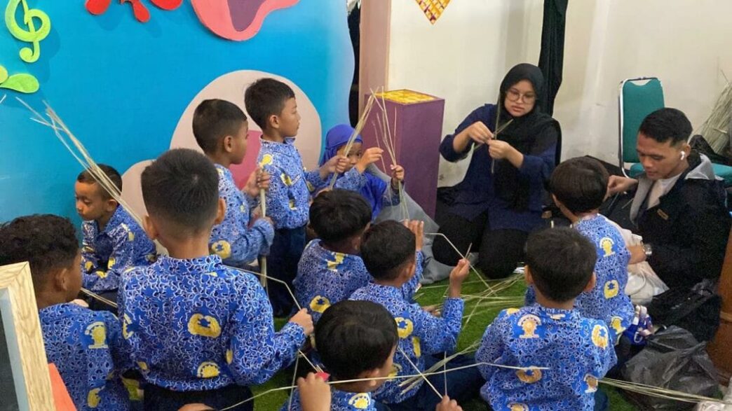 Anak-anak sekolah seragam batik belajar membuat kerajinan anyaman bersama pendamping di Solo Literacy Festival.