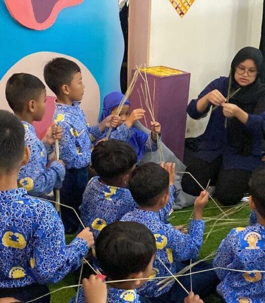 Anak-anak sekolah seragam batik belajar membuat kerajinan anyaman bersama pendamping di Solo Literacy Festival.