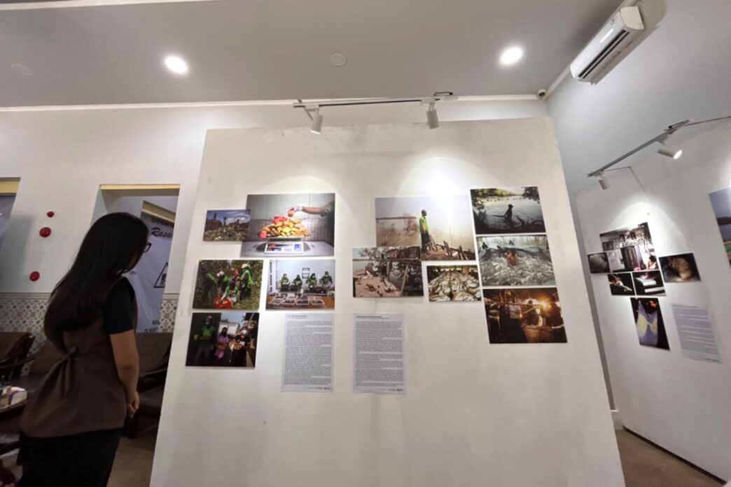 Pengunjung melihat deretan lukisan dan foto dokumenter pada pameran Tanah, Pangan dan Harapan di Kayutangan Malang.