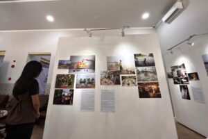 Pengunjung melihat deretan lukisan dan foto dokumenter pada pameran Tanah, Pangan dan Harapan di Kayutangan Malang.