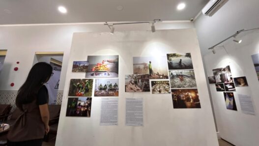 Pengunjung melihat deretan lukisan dan foto dokumenter pada pameran Tanah, Pangan dan Harapan di Kayutangan Malang.
