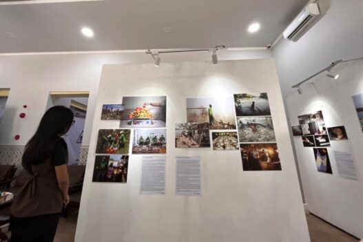 Pengunjung melihat deretan lukisan dan foto dokumenter pada pameran Tanah, Pangan dan Harapan di Kayutangan Malang.