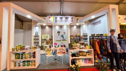 Tampilan depan booth pameran Pemerintah Kabupaten Jember berdesain modern elegan yang memajang ragam produk UMKM unggulan serta plakat Juara 1 Desain Stand Terbaik.
