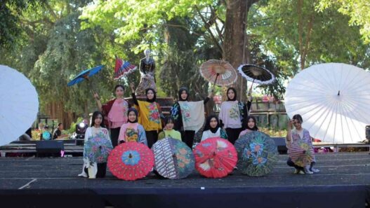 Para peragawati memamerkan payung lukis hias di panggung Festival Payung Indonesia Taman Balekambang.