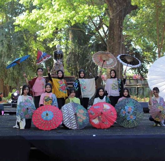 Para peragawati memamerkan payung lukis hias di panggung Festival Payung Indonesia Taman Balekambang.