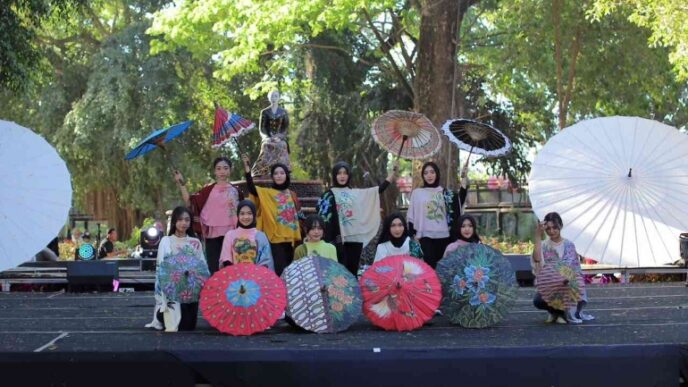 Para peragawati memamerkan payung lukis hias di panggung Festival Payung Indonesia Taman Balekambang.