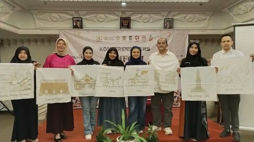 Para penyelenggara memegang kain putih bermotif sketsa ikon Yogyakarta saat Konferensi Pers Simfoni 1001 Pembatik.