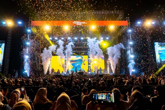 Panggung konser musik megah dengan efek kembang api dan konfeti bertuliskan Konser Persembahan Cinta.