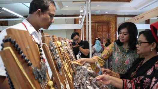 Dua wanita sedang melihat perhiasan di stand pameran.