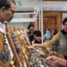 Dua wanita sedang melihat perhiasan di stand pameran.