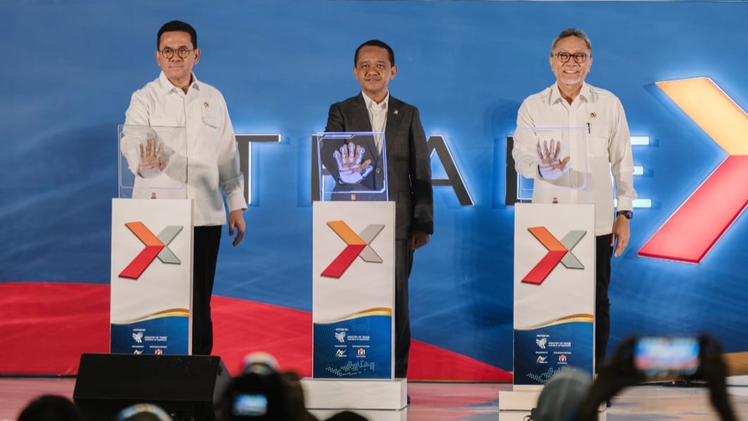 Tiga pejabat pemerintah menempelkan telapak tangan pada layar pemindai digital di podium Trade Expo Indonesia sebagai tanda peresmian acara.