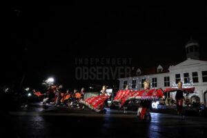 Sekelompok penari tradisional membentangkan kain merah lebar saat tampil di panggung terbuka di depan Museum Fatahillah Kota Tua pada malam hari.