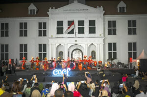 Penari dengan pakaian adat tradisional tampil di atas panggung terbuka di depan gedung bersejarah Museum Fatahillah (Gouverneurskantoor) Jakarta pada malam hari di hadapan penonton.