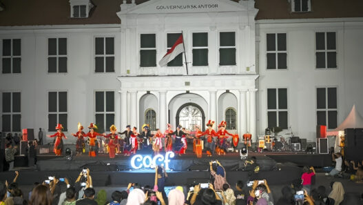 Penari dengan pakaian adat tradisional tampil di atas panggung terbuka di depan gedung bersejarah Museum Fatahillah (Gouverneurskantoor) Jakarta pada malam hari di hadapan penonton.