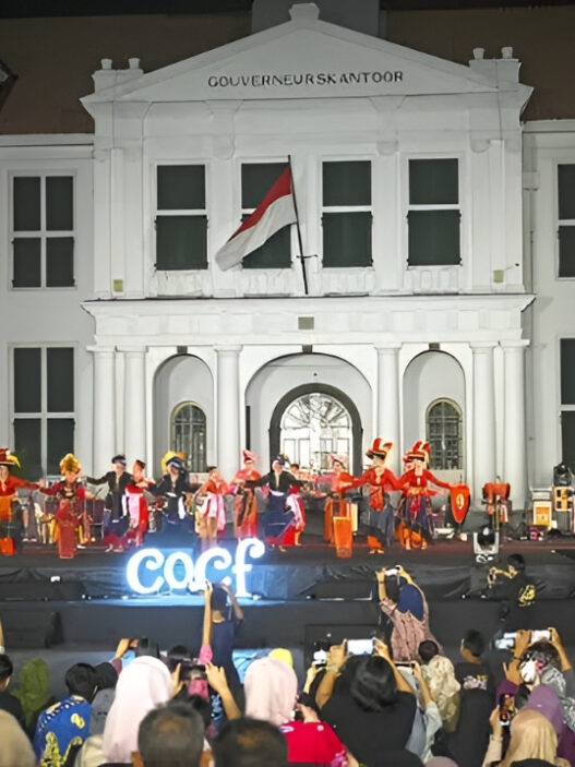 Penari dengan pakaian adat tradisional tampil di atas panggung terbuka di depan gedung bersejarah Museum Fatahillah (Gouverneurskantoor) Jakarta pada malam hari di hadapan penonton.