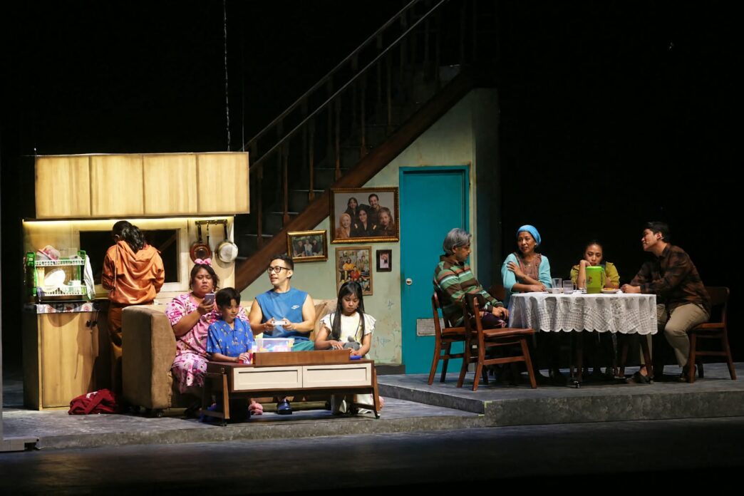 Para pemeran teater dalam set panggung berupa interior rumah modern dan area makan keluarga.