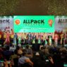 Suasana seremoni pembukaan pameran ALLPack Indonesia 2026 di panggung utama JIExpo Kemayoran dengan confetti emas serta jajaran pejabat dan tamu undangan di atas panggung.