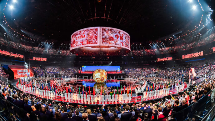 Suasana megah stadium dalam panggung pembukaan WorldSkills Shanghai 2026 yang dipenuhi bendera peserta dan layar silinder besar bertuliskan China.